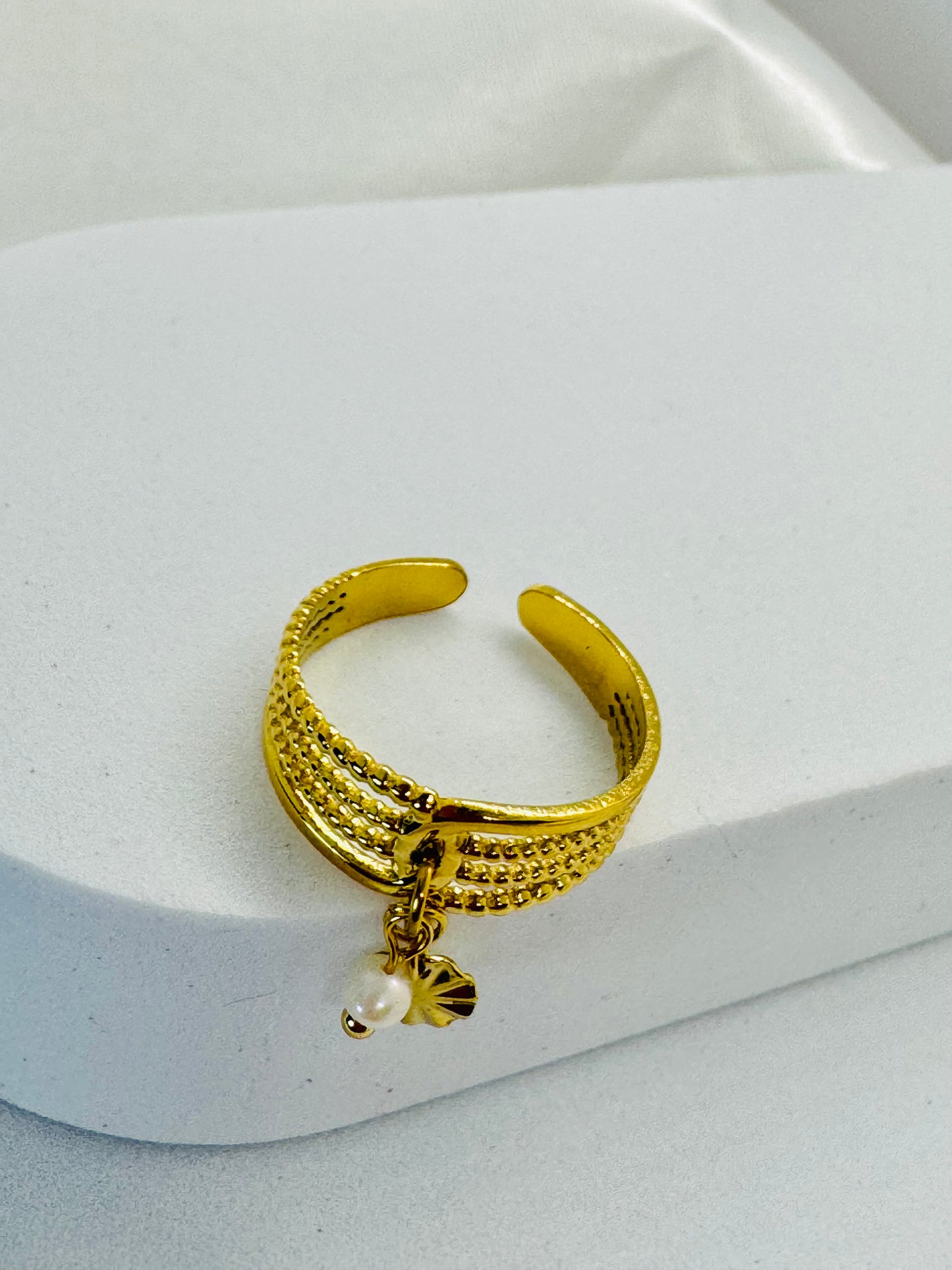 Bagues dorées ajustables avec pendentifs fleur et rond.