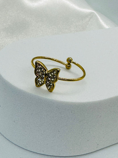 Bagues dorées ajustables avec papillon en strass.